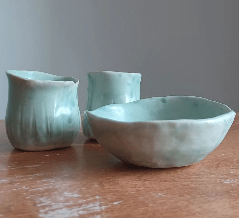 Pale seagreen glazed handbuilt and carved small stoneware clay vessels and pinch pot.