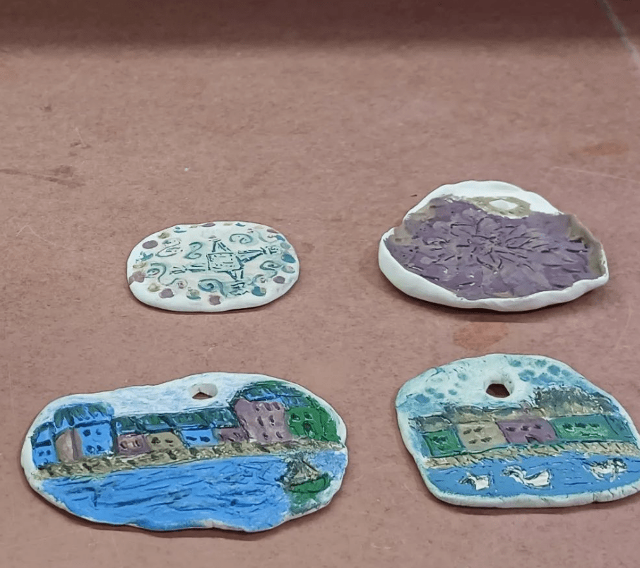 Underglaze painting hand carved clay ornaments from December 2023.